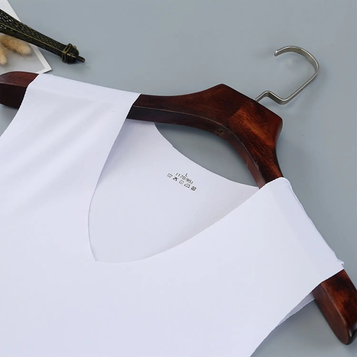 Men ice silk v-neck sleeveless tank top in white made of smooth fabric displayed on a wooden hanger