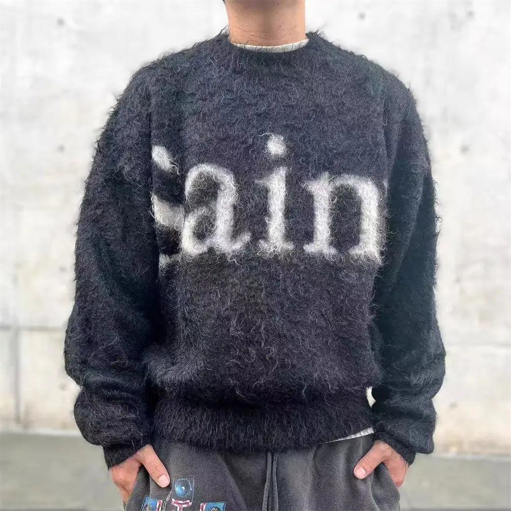 sin刺繍コレクションの、胸元全体に白い「ain」レタリングをあしらったブラックのフワフワオーバーサイズニットセーター。