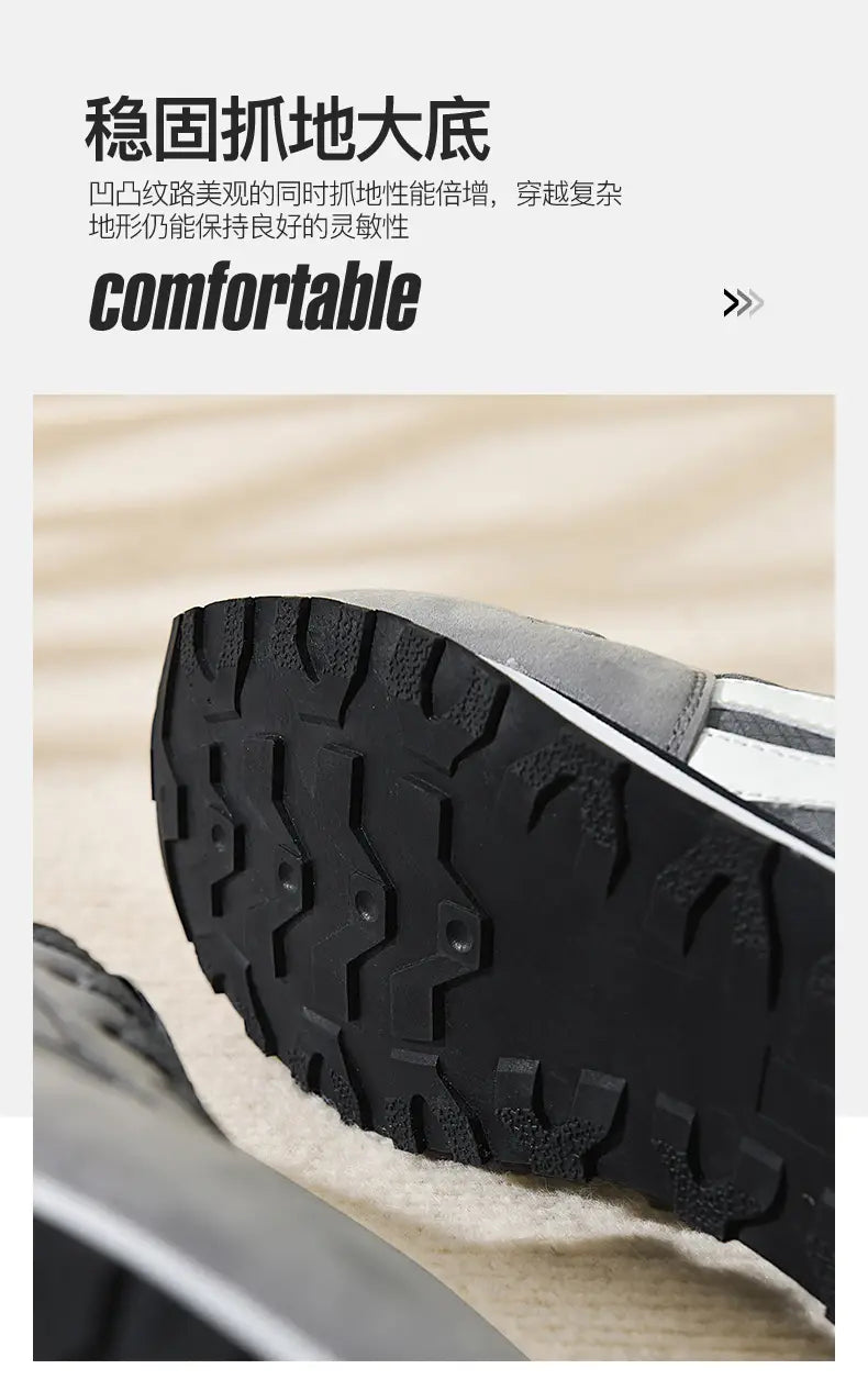 Herrenfreizeitsneaker in Grau und Weiß zum Gehen mit schwarzer Gummisohle und markantem Profil sowie silbernen Streifen entlang der Seite.