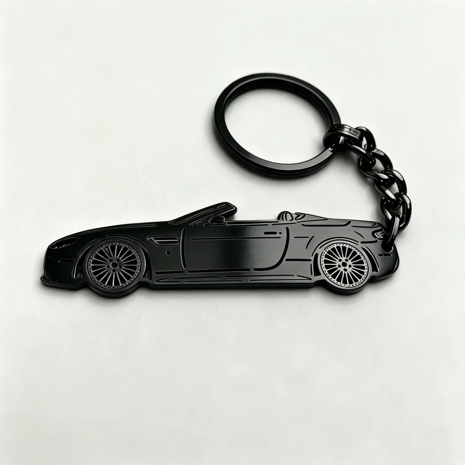 black metallic custom car model keychain shaped like a convertible sports car with detailed wheels and body lines used as a personalized vehicle key pendant