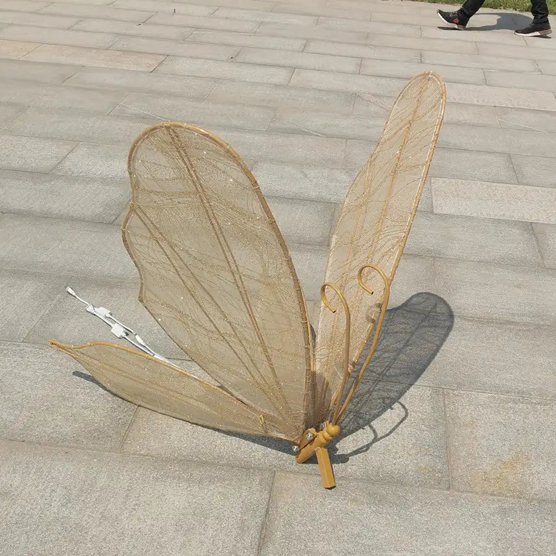 Leuchtende Schmetterlingsflügel, hängende Hochzeitstennenlichtanlage, mit goldenen Schmetterlingsflügeln und einem zarten, netzartigen Design sowie einer dezent funkelnden, schimmernden Textur.