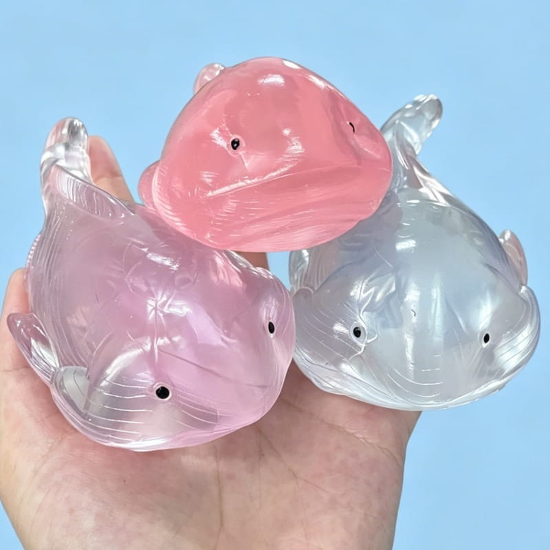 trois balles anti-stress souples en forme de baleine comme jouets d’occupation, translucides, en rose et transparent, avec des yeux à petits points noirs, pour soulager le stress et stimuler la sensorialité
