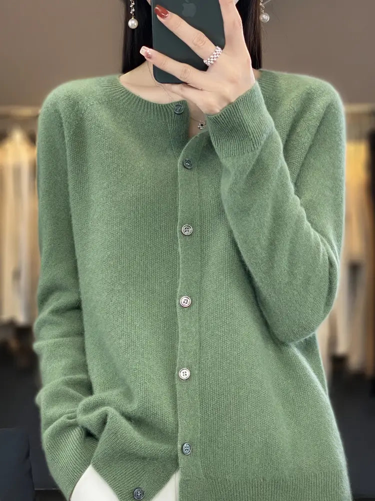 A soft sage green merino wool cardigan for women featuring a round neckline and silver-toned buttons in cashmere knit.