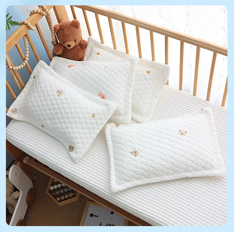 新生児用の、刺繍のくまの顔と小さなゴールドの星のディテールをあしらった白いキルティング加工のアイスシルクベビークーリング枕。