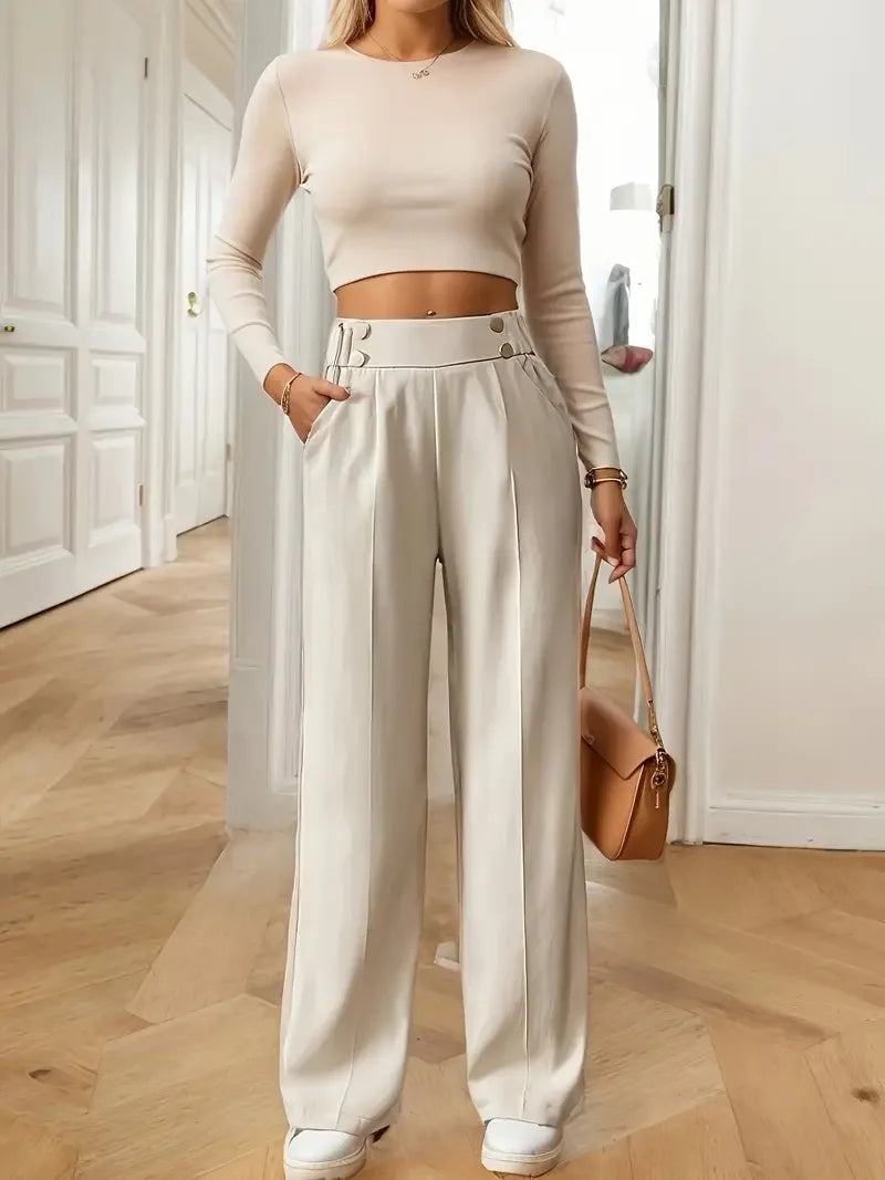 pantalones de pierna ancha color crema de cintura alta con corte entallado elegante y pliegues frontales sutiles, ideales para un uso formal y casual.