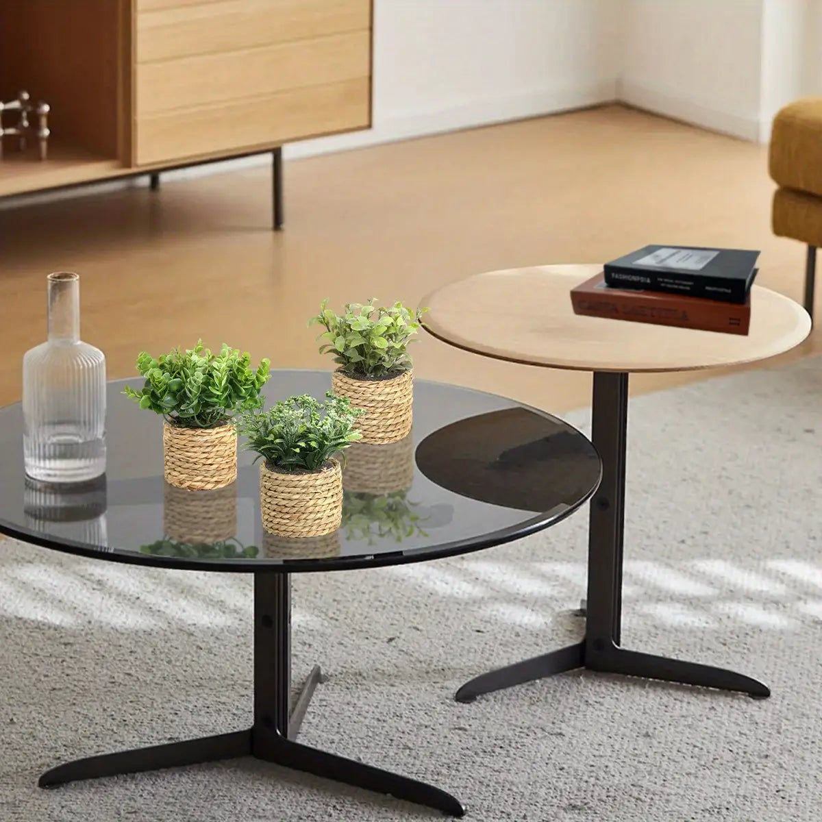 black glass-top coffee table with sleek modern design and sturdy black metal tripod legs displayed alongside artificial plants small potted eucalyptus 17cm highlighting small potted plants and eucalyptus flowers.