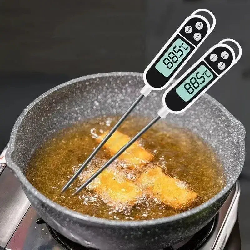 Zwei digitale Fleischthermometer mit schwarzen und weißen Gehäusen, silbernen Fühlern und grünen LCD-Displays, die jeweils 88,5 °C anzeigen; eingesetzt in eine Pfanne mit Bratgut zur sofortigen Ermittlung der Temperatur.