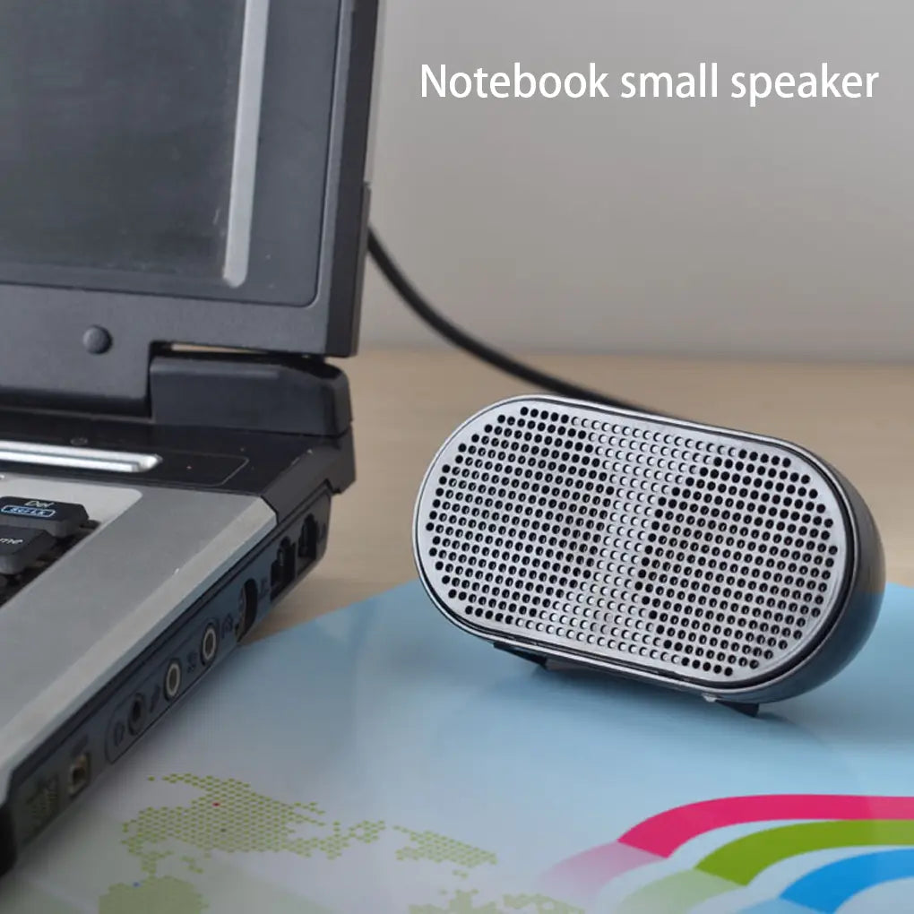 Kompakter, oval geformter USB-Mini-Lautsprecher für Laptops mit schwarzem und silbernem perforiertem Gitter-Design sowie Eigenschaften für eine tragbare Computer-Soundbar.