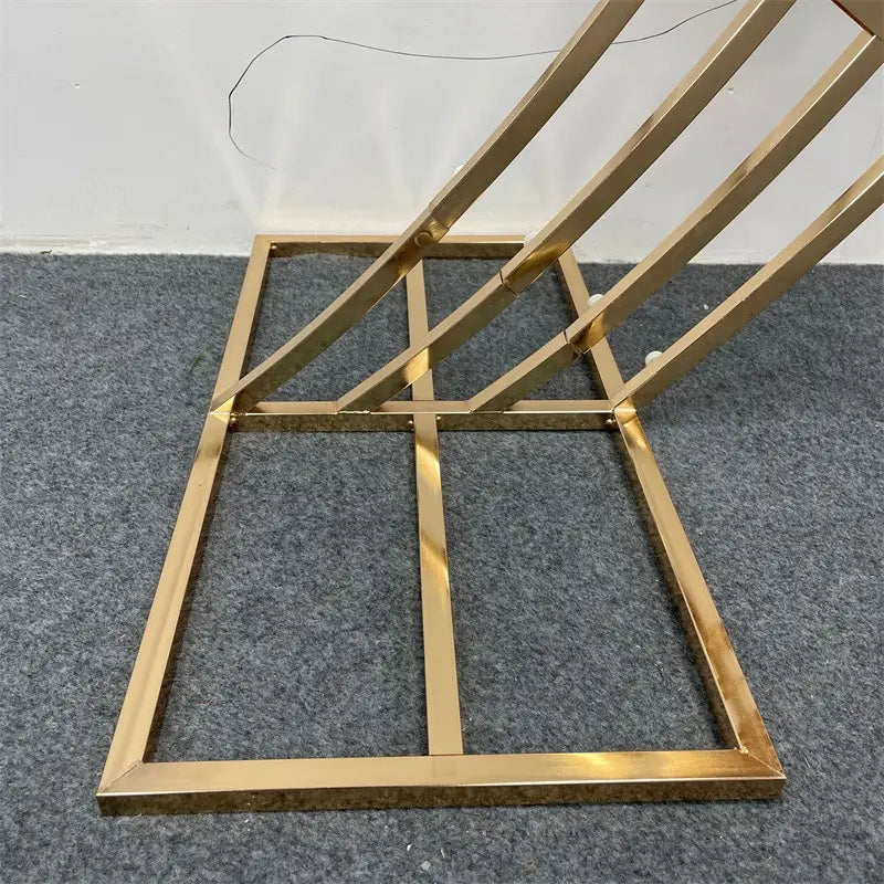 table d’appoint latérale géométrique en métal ton doré à cadre moderne angulaire pour servir de support de fond d’arche de mariage dorée pour des réceptions.