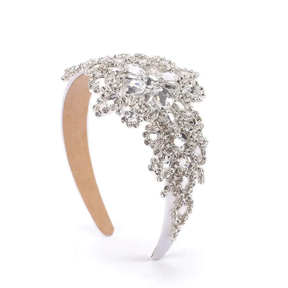 Serre-tête de fleurs en strass argenté étincelant présentant un motif floral complexe, avec des cristaux en cascade et des pierres centrales plus grandes, pour un usage élégant d’accessoire de coiffure.
