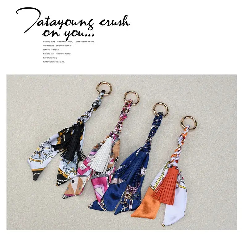 Quatre porte-clés à glands de foulard en soie colorés, présentant des motifs imprimés uniques et des glands assortis pour sacs.