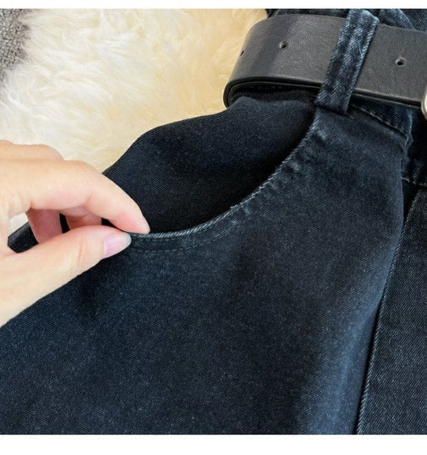 black denim jeans with a sturdy black leather belt featured as part of a denim jumpsuit off shoulder summer romper.
