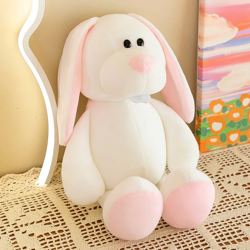 Un suave conejo de peluche blanco con orejas internas rosadas, nariz y patas se encuentra sobre un tapete redondo de encaje, como parte de peluches de animales de la jungla y muñecos blandos.