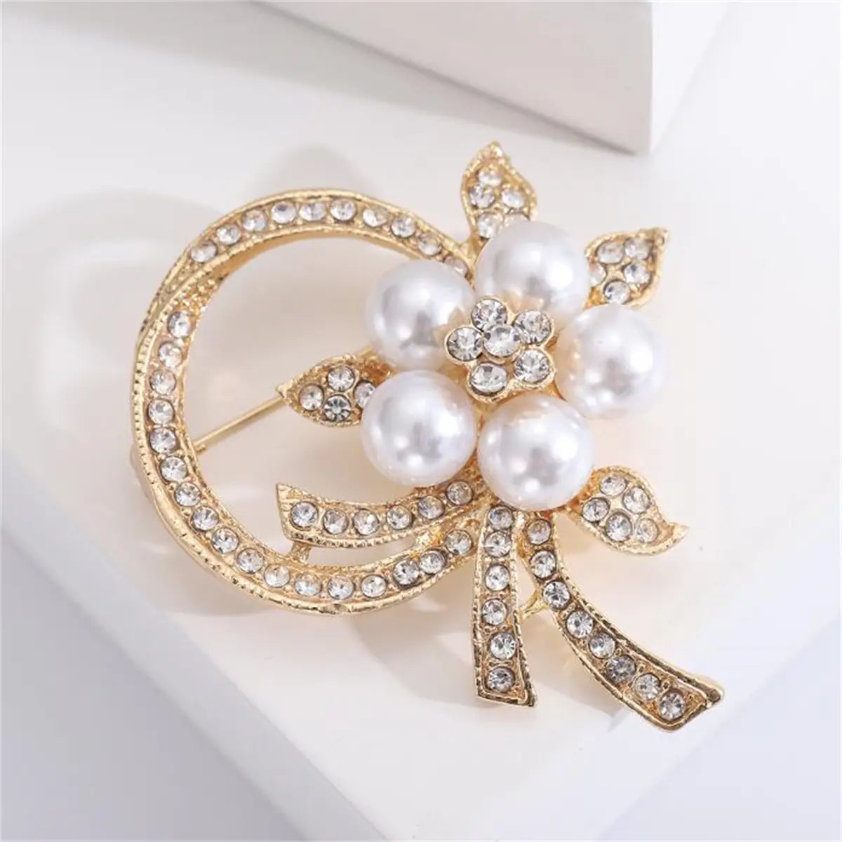 Broche floral con baño en tono dorado, adornado con perlas blancas y pedrería brillante, para alfiler de moda unisex de lujo.