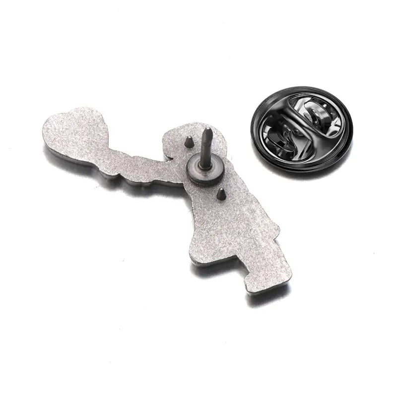 Épingle émaillée argentée scintillante en forme d’une silhouette tenant un cœur, issue de la collection de broches à épingle émaillée « street art » de Banksy.