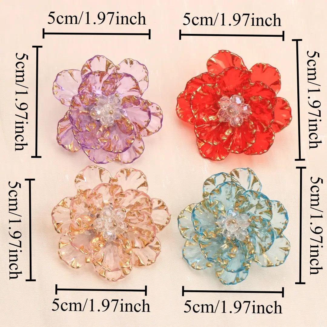 Quatre broches en forme de fleur de cristal translucide, en pourpre, rouge, pêche et bleu, avec des pétales bordés d’or et des centres en cristal transparents, destinées à un usage d’accessoire de mode.