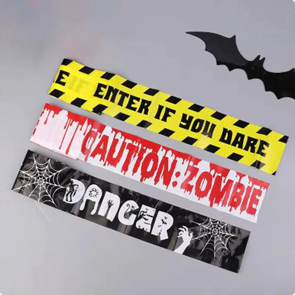 three halloween caution tape strips featuring bold spooky designs and warning text used as a party warning barrier for halloween events