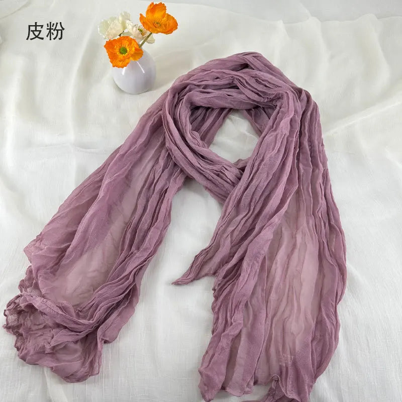 Écharpe en coton et lin plissé violet poussière doux, avec de délicates ondulations et une texture de mousseline de chiffon légèrement transparente.
