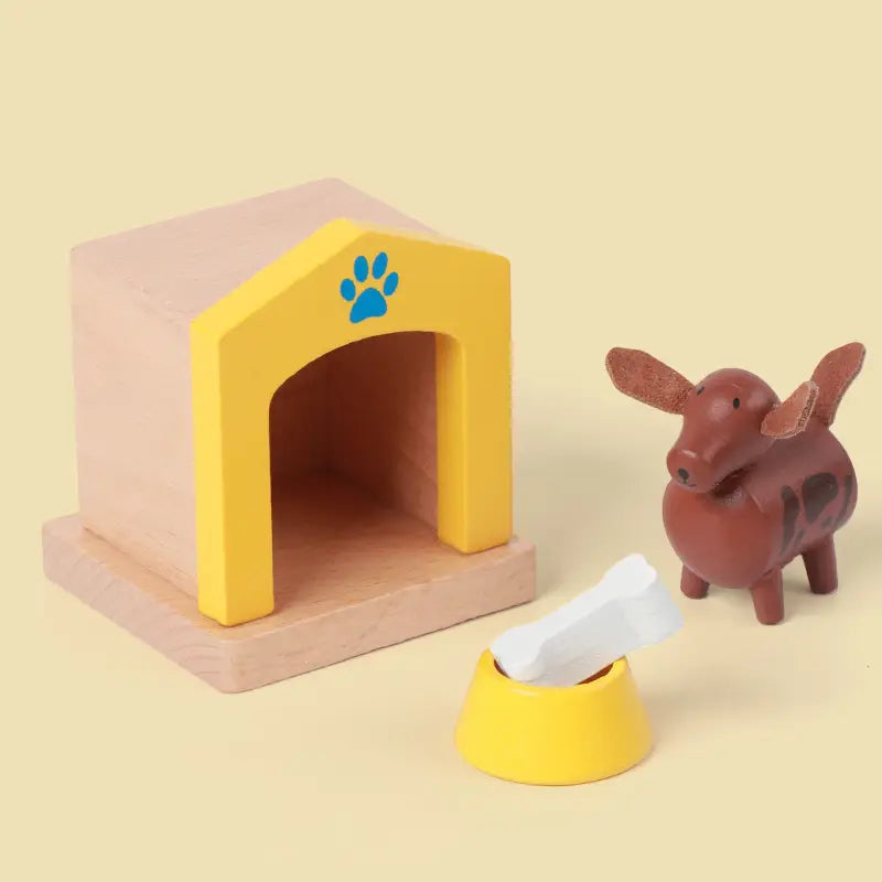 Gelbes Holz-Hundehäuschen mit blauem Pfotenabdruck auf der Vorderseite aus dem Holz-Puppenhaus-Möbelset für Kinder als Miniaturspielzeug.