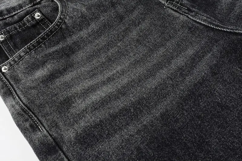 Men flare jeans in distressed dark gray denim with a faded texture and silver rivets on the pocket.