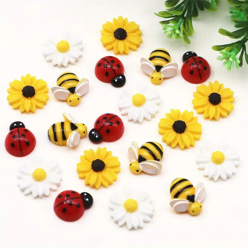 Bright yellow and black striped bee resin figurines with white wings, red ladybug charms with black spots, and vibrant sunflowers and daisies in a 20pcs mixed resin daisy bee and ladybug flatback charms set.