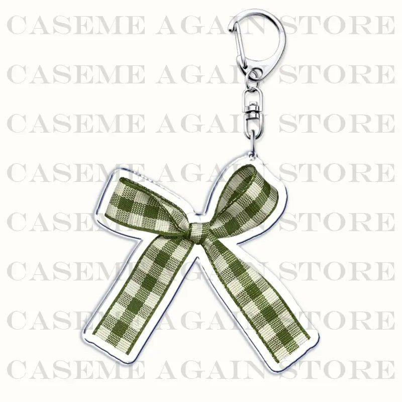 A translucent green and white checkered acrylic bow-shaped keychain with a silver-toned metal clasp designed as a Gracie Abrams anime fan gift.