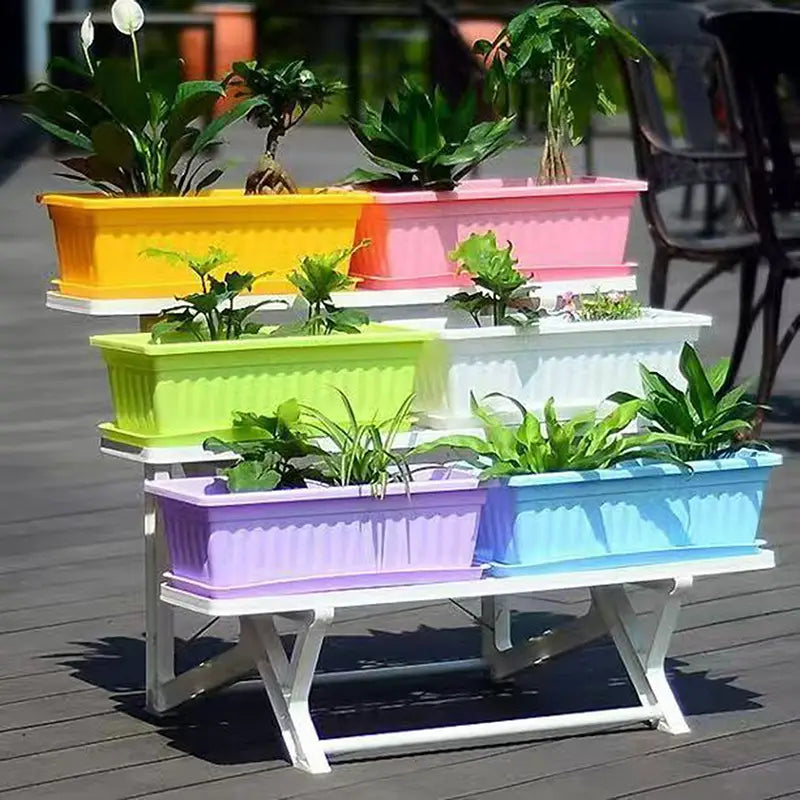 Macetas rectangulares de plantación apiladas en niveles, hechas de plástico vibrante amarillo, rosa, verde, blanco, morado y azul, con lados acanalados.