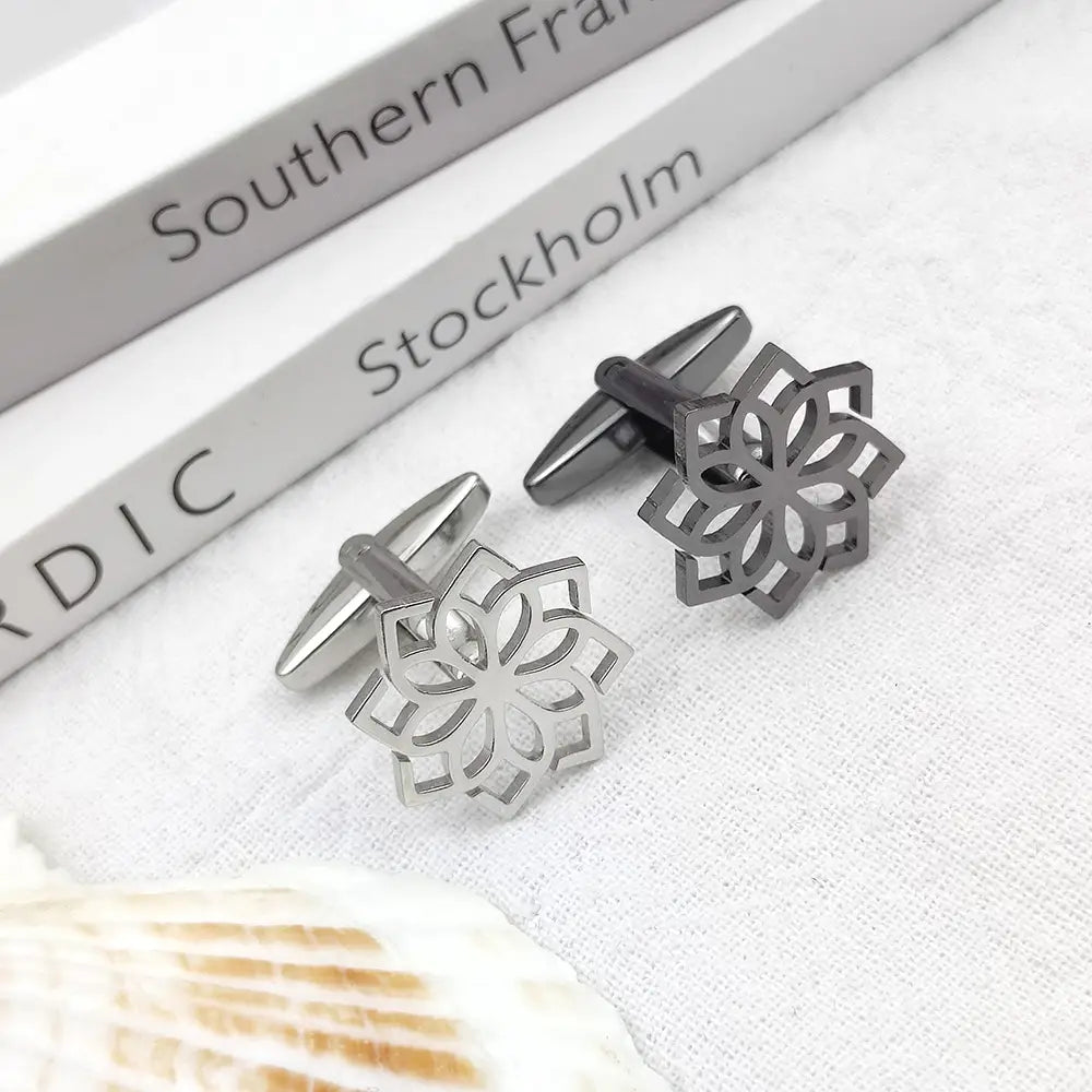 A pair of sleek metallic stainless steel floral cufflinks for men featuring an intricate cutout design.