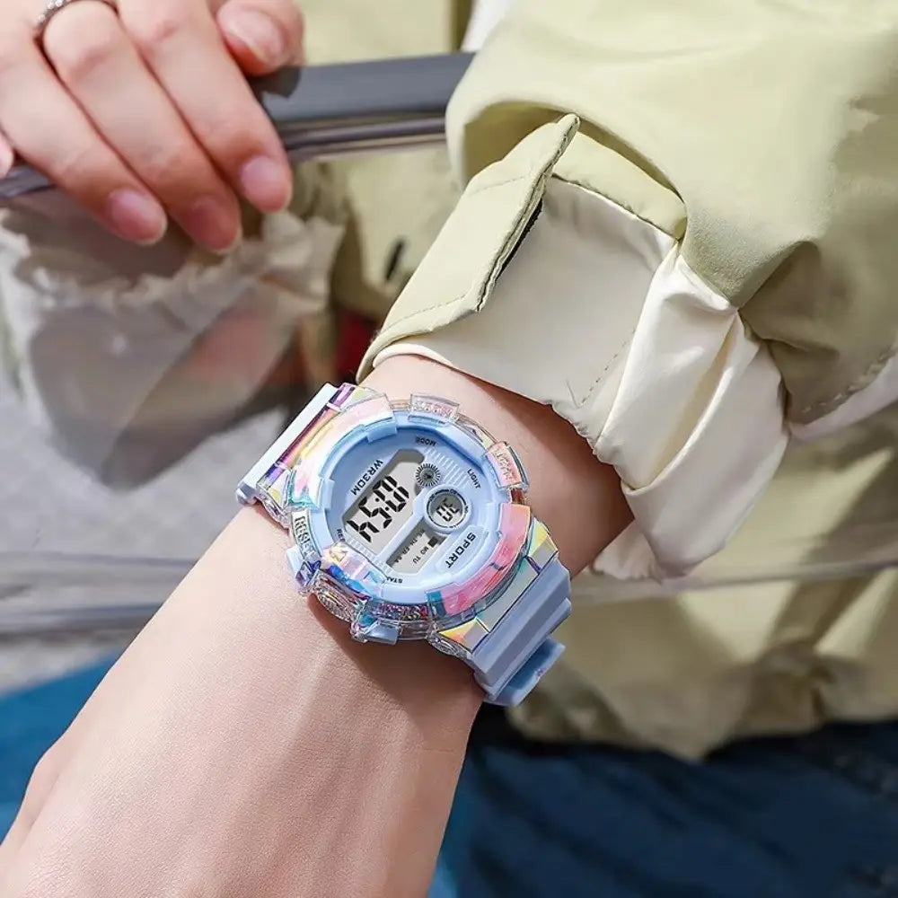 un vibrante reloj digital deportivo iridiscente para niños con material de correa de silicona, material de caja de resina translúcida y acentos multicolores colocados en la muñeca.