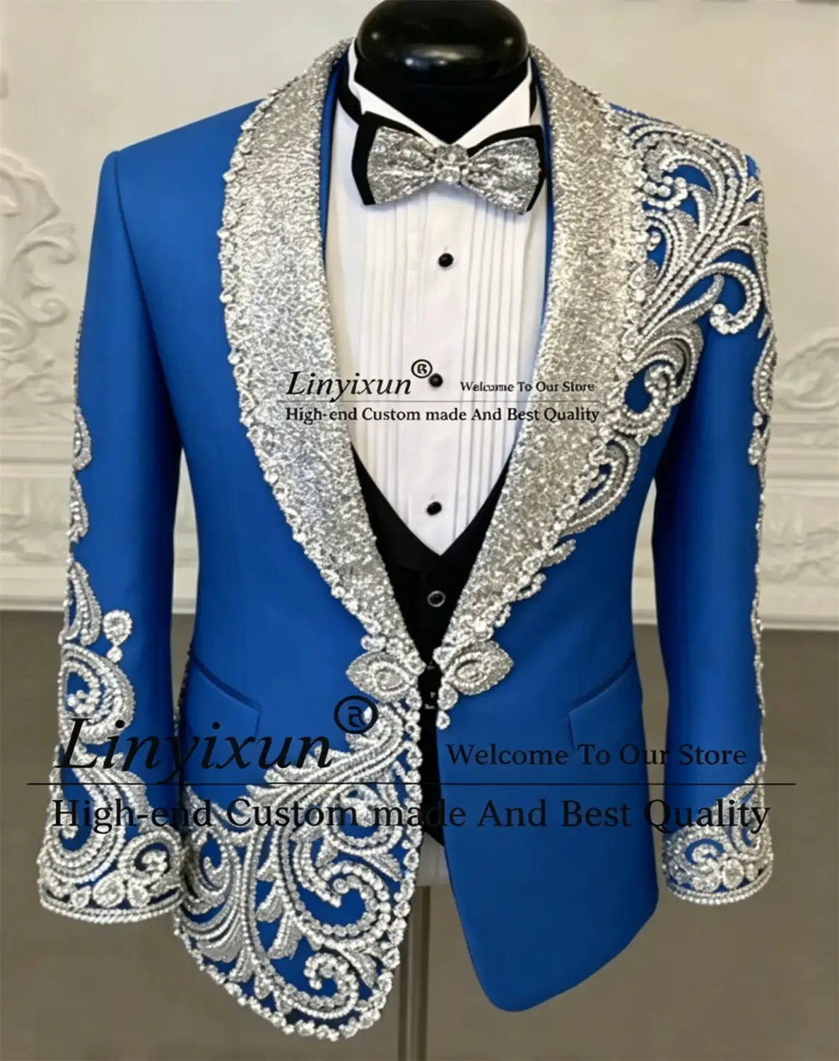Veste de tuxedo bleu royal éclatant, en velours noir, présentant une broderie argentée complexe et des ornements de sequins sur les revers, les épaules, les poignets et les bordures avant, conçue pour un costume de tuxedo de mariage pour hommes.