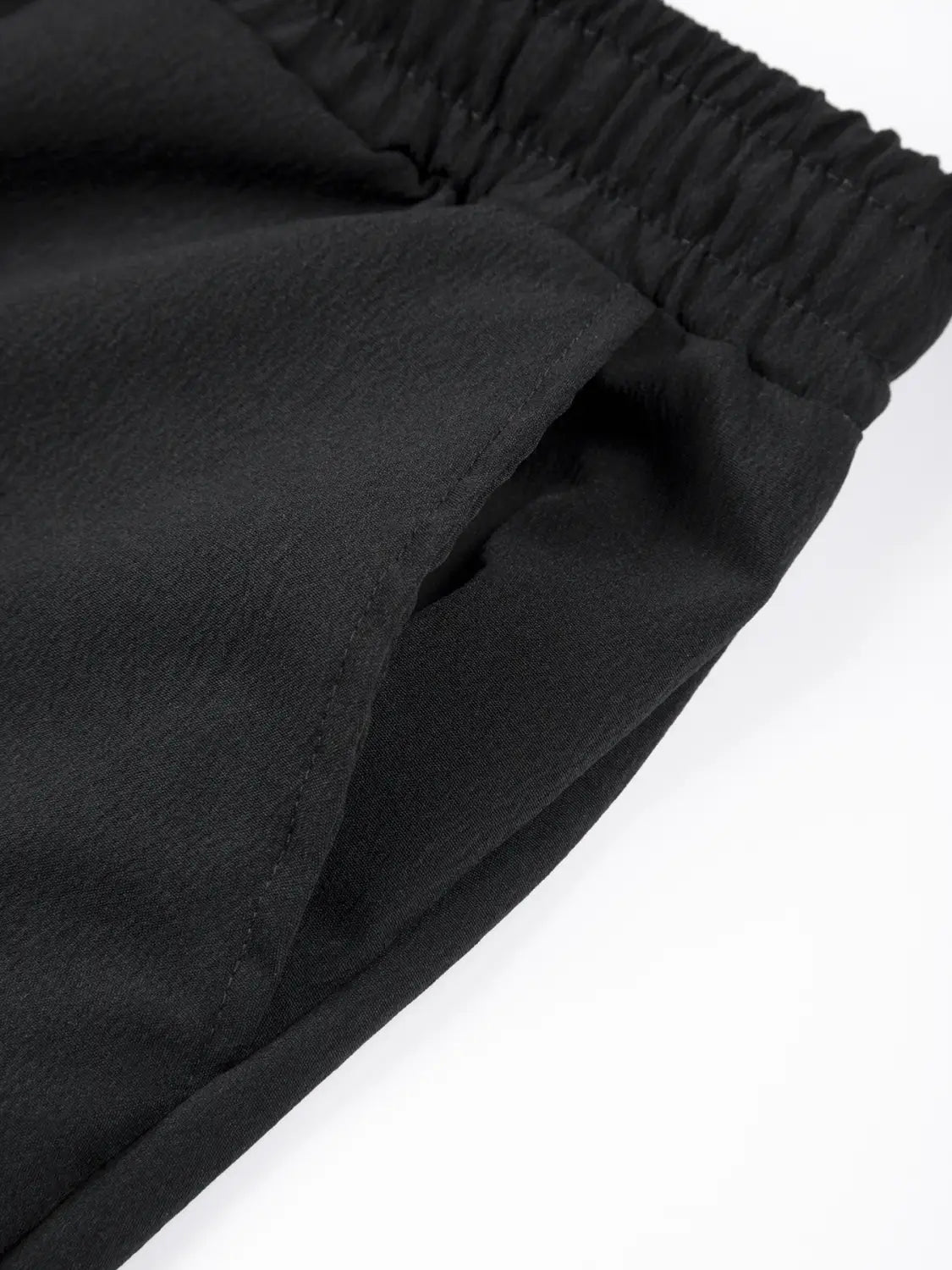 Leichte Leinenjogginghosen für Herren in Schwarz mit elastischem Bund und glatter, matter Stoffstruktur.