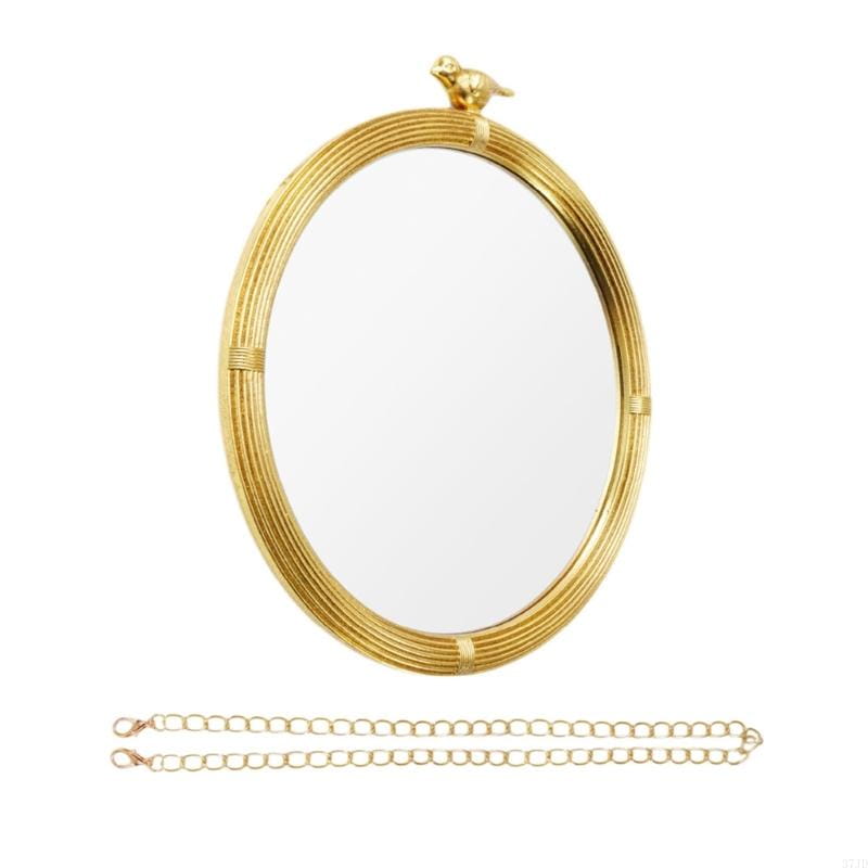 Miroir décoratif ovale à la finition dorée, à monture ovale en résine, avec un motif en rotin tressé, et une petite figurine d’oiseau posée au sommet, pour un usage mural intérieur.