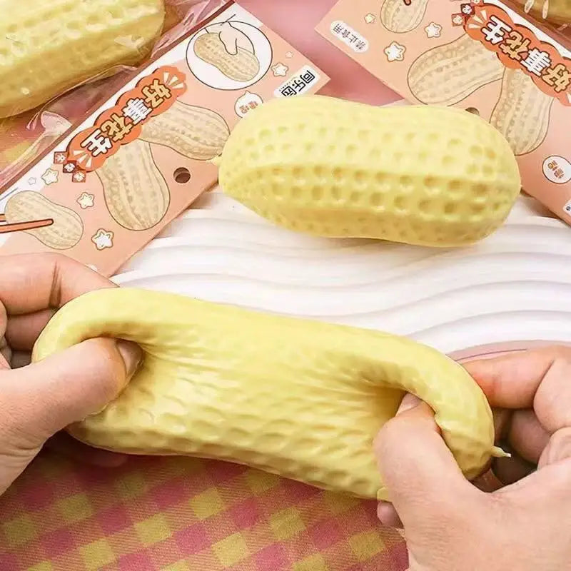 Jouet antistress souple en forme de cacahuète jaune, fabriqué dans une matière souple, conçu pour être pressé entre les mains et pour la relaxation.
