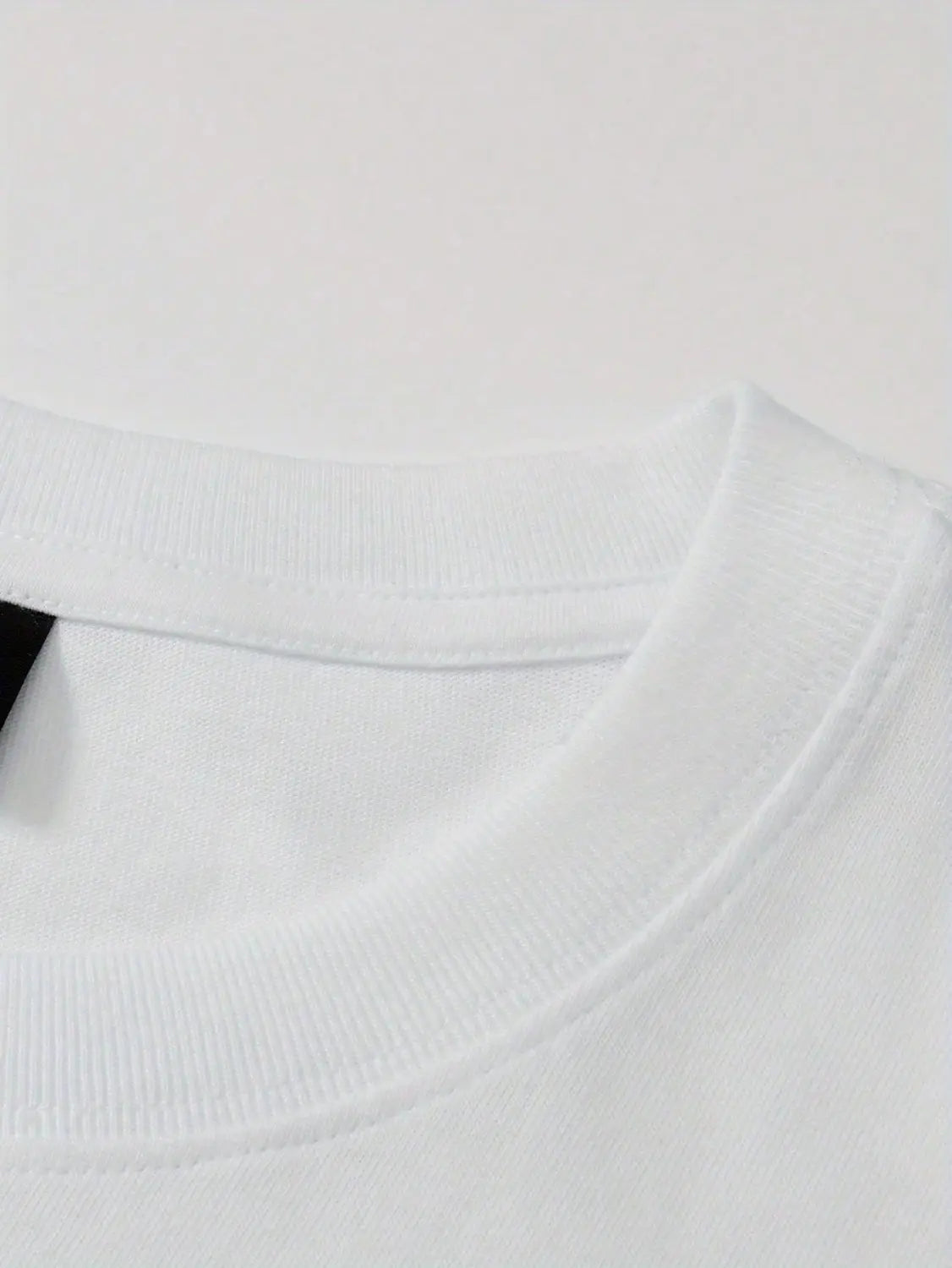 White cotton crew neck collar of a graphic print oversized men short sleeve t shirt.