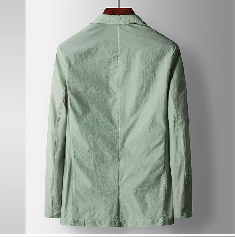Eine hellgrüne Polyester-Herren-Freizeit-Blazer-Anzugjacke mit langen Ärmeln, dezentem Strukturrelief und klaren Linien, entworfen für die Verwendung im Herren-Hombre-Stil.