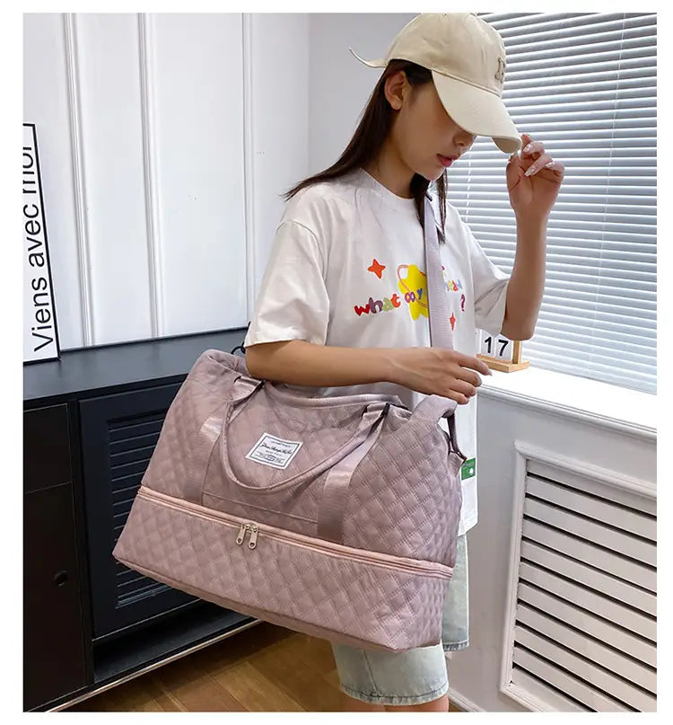 Bolsa de viaje tipo duffel acolchada grande tote weekender rosa con bolsillo frontal con cierre y asas superiores.