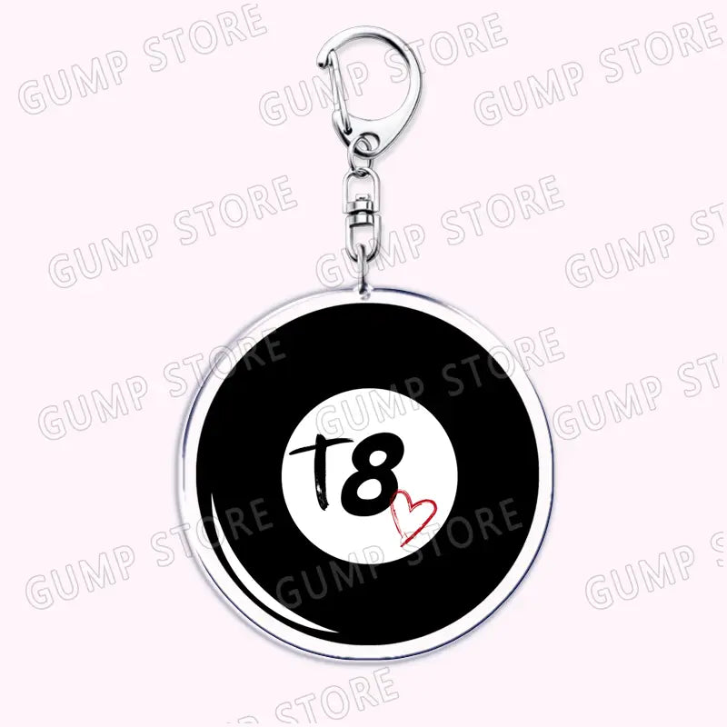 Silver-framed circular acrylic keychain featuring a black billiard ball design with a white center t8 in stylized font and a small red heart accent for Tate Mcrae music fan gift.