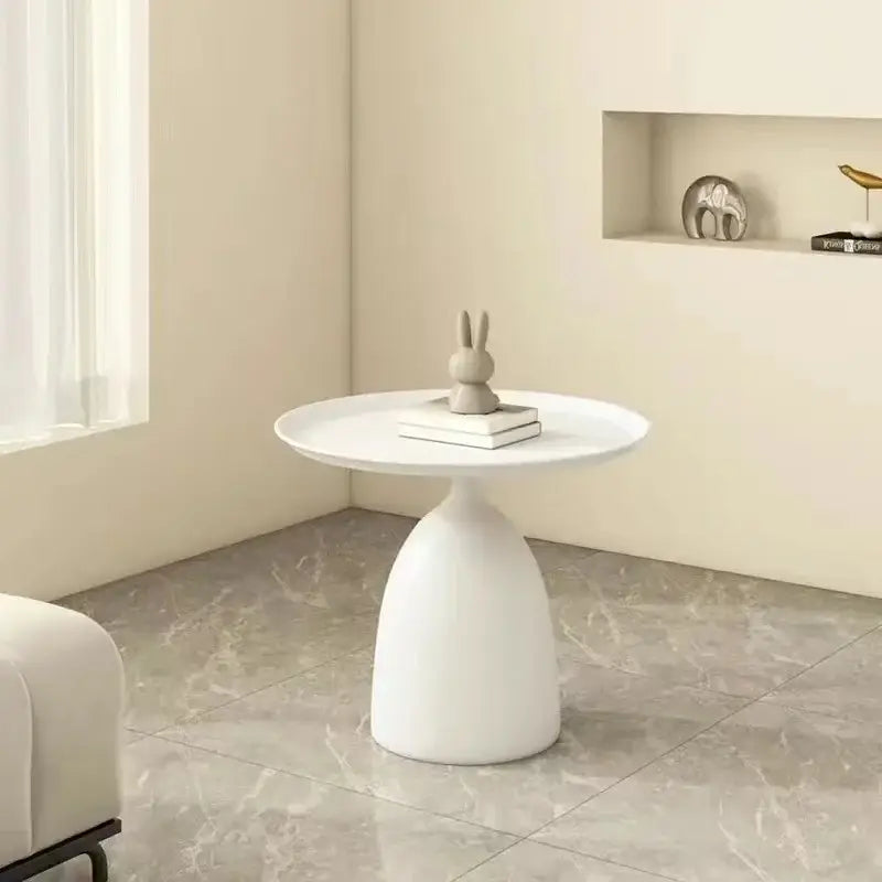 White ceramic coffee table with a smooth rounded top and tapered pedestal base for modern living room use.