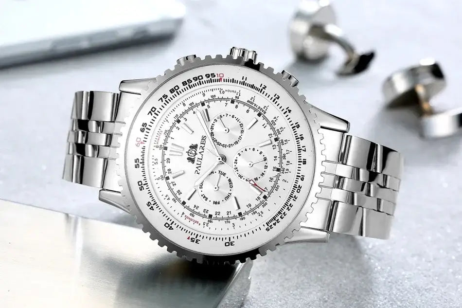 Silberne Edelstahl-Paula-Laxer-Chronographenuhr mit weißem Zifferblatt, mehreren Hilfszifferblättern und strukturierter Lünette, dargestellt als automatische mechanische Uhr für Herren mit blauem Zifferblatt.