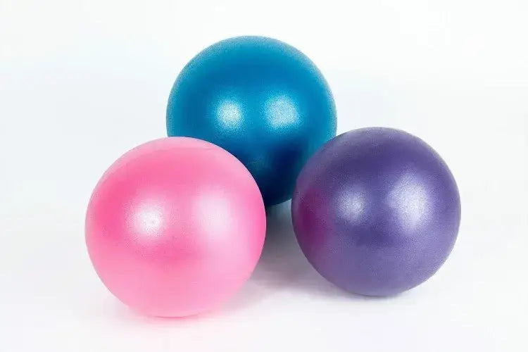 three glossy anti-burst yoga balls in pink teal and purple designed for balance training with superior air leakage resistance