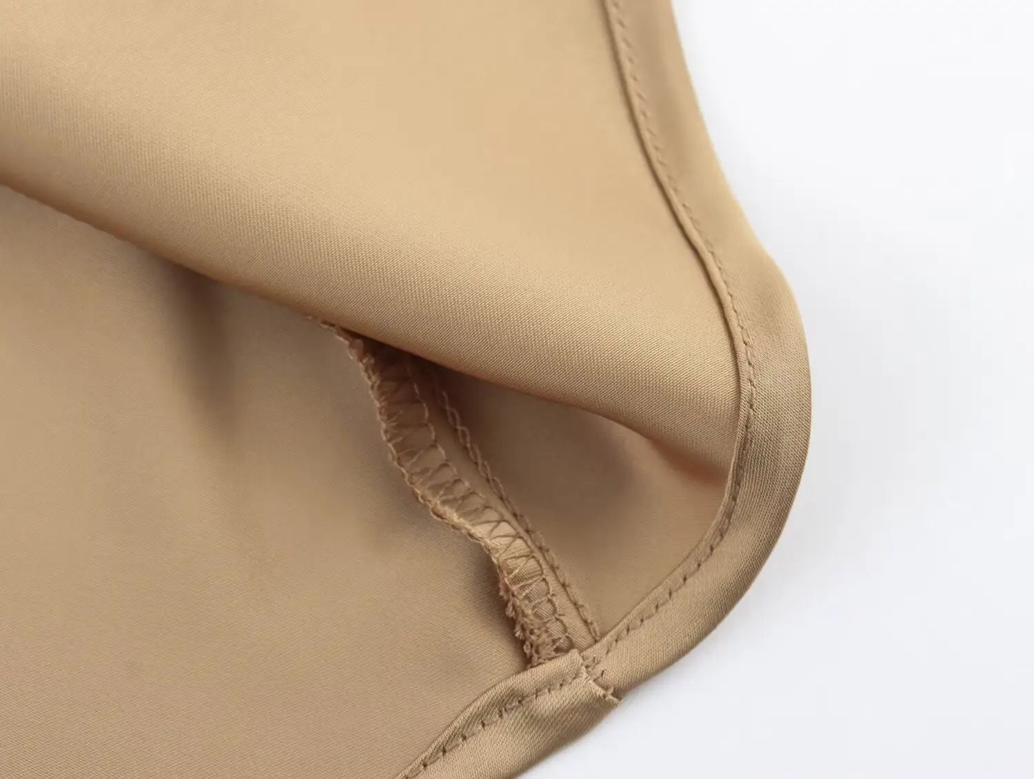 Jupe midi en satin beige, à taille haute, texture de tissu lisse et élégante, avec des coutures soignées le long du bord.