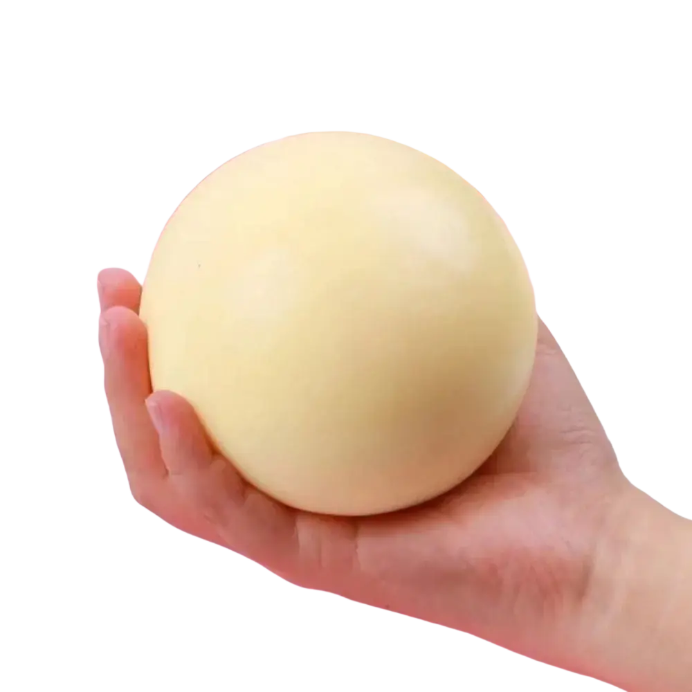 A soft pale yellow spherical squishy ball held in hand stress relief anti-anxiety sensory fidget toy
