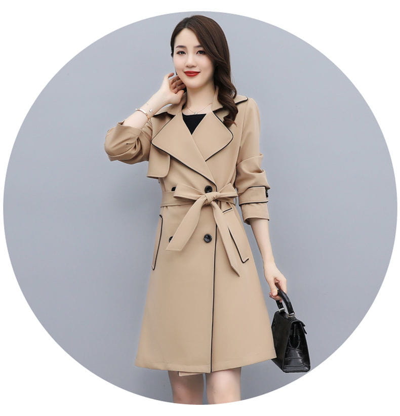 Beige women double breasted trench coat with black trim and belted waist made from lightweight material for stylish outerwear.