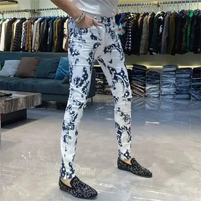 Men black floral slim fit jeans featuring white skinny fabric with bold black floral pattern and subtle distressing details.