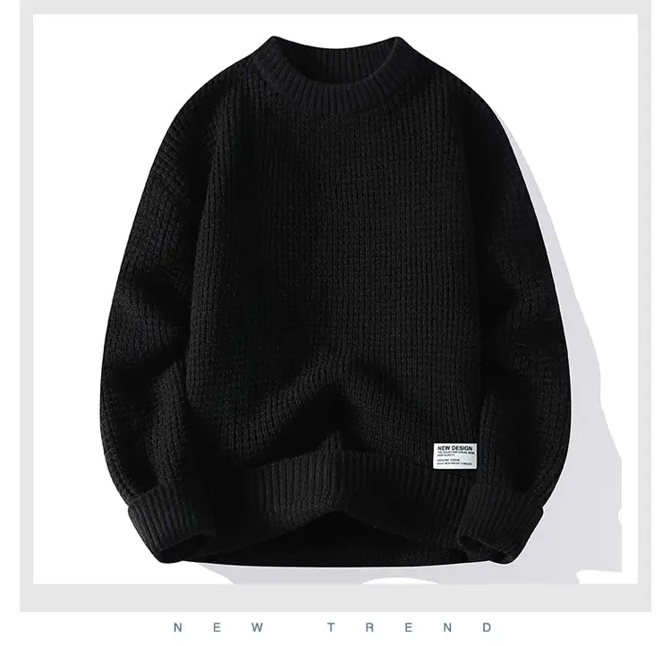 Moownuc Herren-Waffelstrick-Pullover im lässigen Stil in Schwarz mit geripptem Strick, Rundhalsausschnitt und entspannter Passform; mit einem kleinen weißen Label auf dem unteren linken Ärmel.