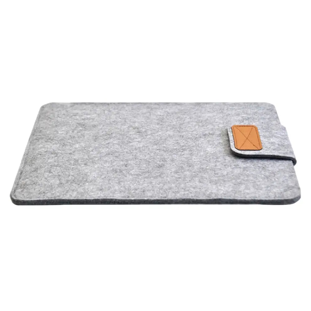 gray felt laptop bag sleeve for macbook air with tan leather flap and x-shaped stitched detail designed as a tablet bag and laptop bag accessory