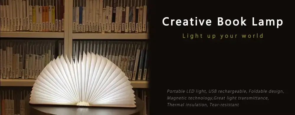 Luz LED plegable blanca con forma de libro que muestra un brillo suave colocada sobre una superficie plana, vista frontal.