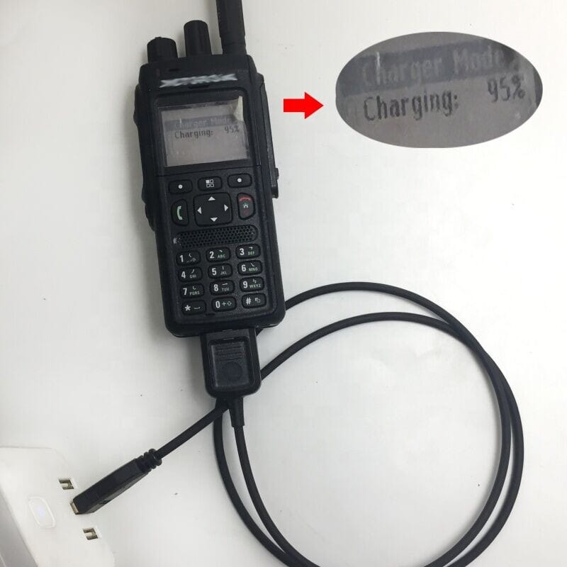 数値キーパッドおよびアンテナを備えた黒色の携帯型Motorola Tetra Mtp3150トランシーバーで、12Vカーチャージャーに接続されています。