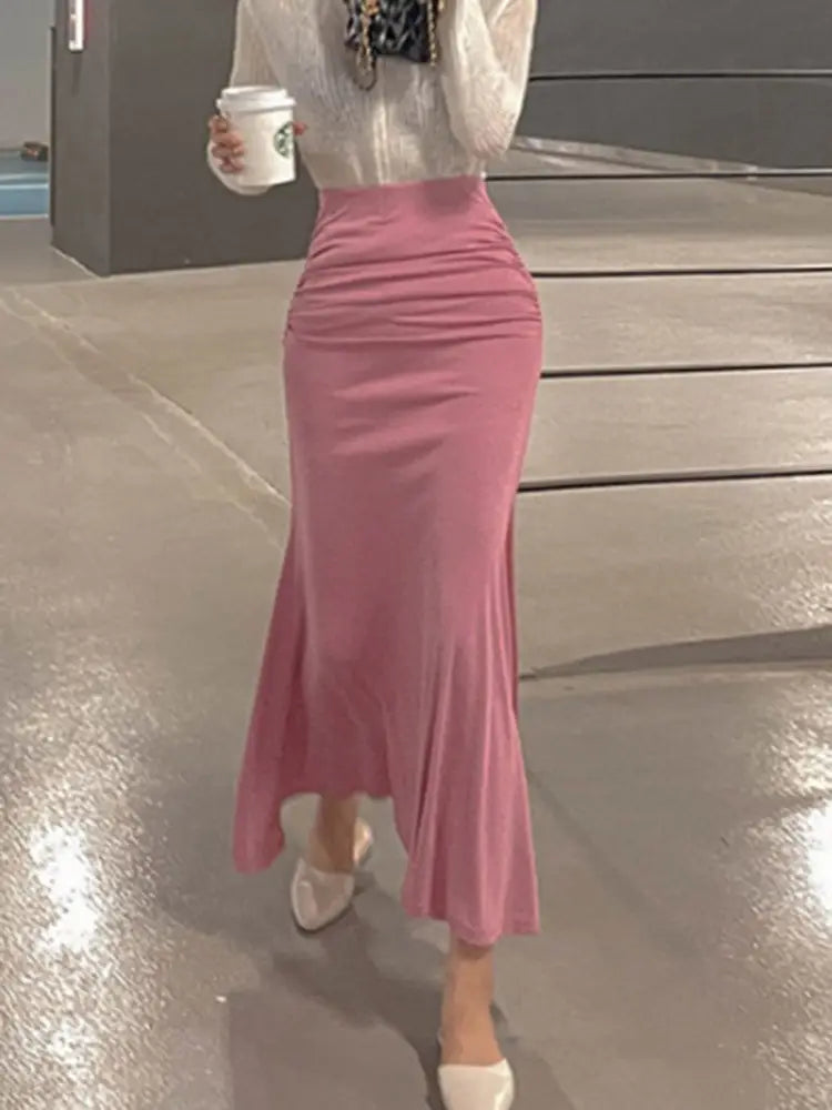 Ein zarter rosafarbener Meerjungfrauen-Midirock mit hoher Taille und gerafften Details, entworfen für elegante Anlässe.