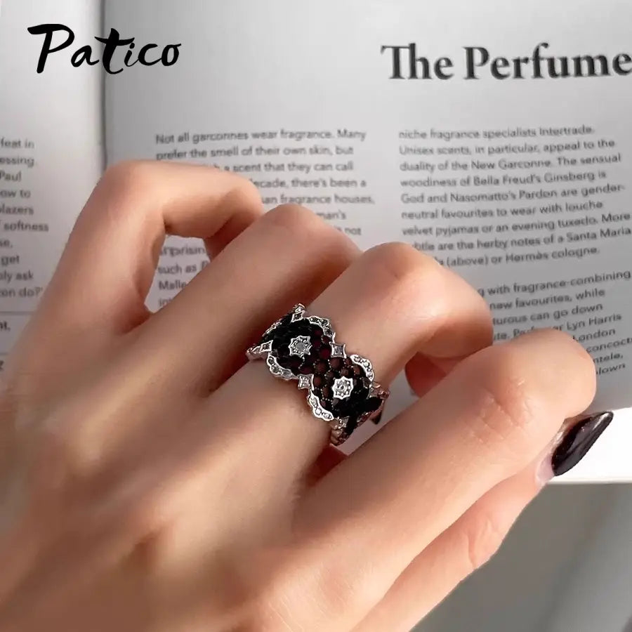 Sterling silver black geometric ring for women with a vintage-inspired design featuring intricate floral detailing and embedded black gemstones.